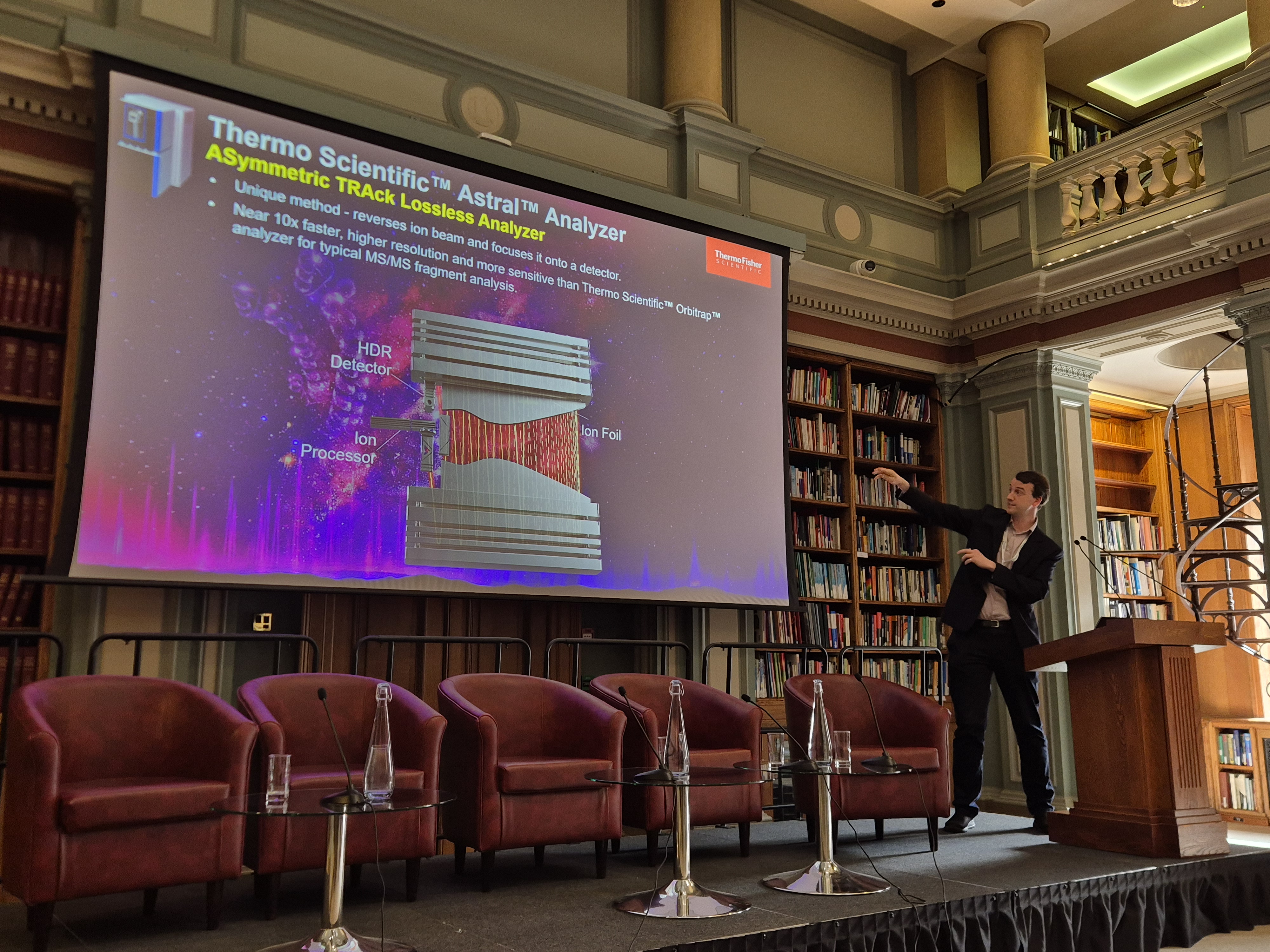 Hamish Stewart stands in front of a large colourful screen