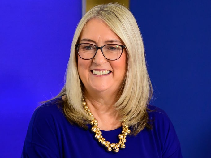 Baroness Smith of Malvern, the Minister for Skills at Department for Education and Department of Work and Pensions, smiles wearing glasses and a blue shirt