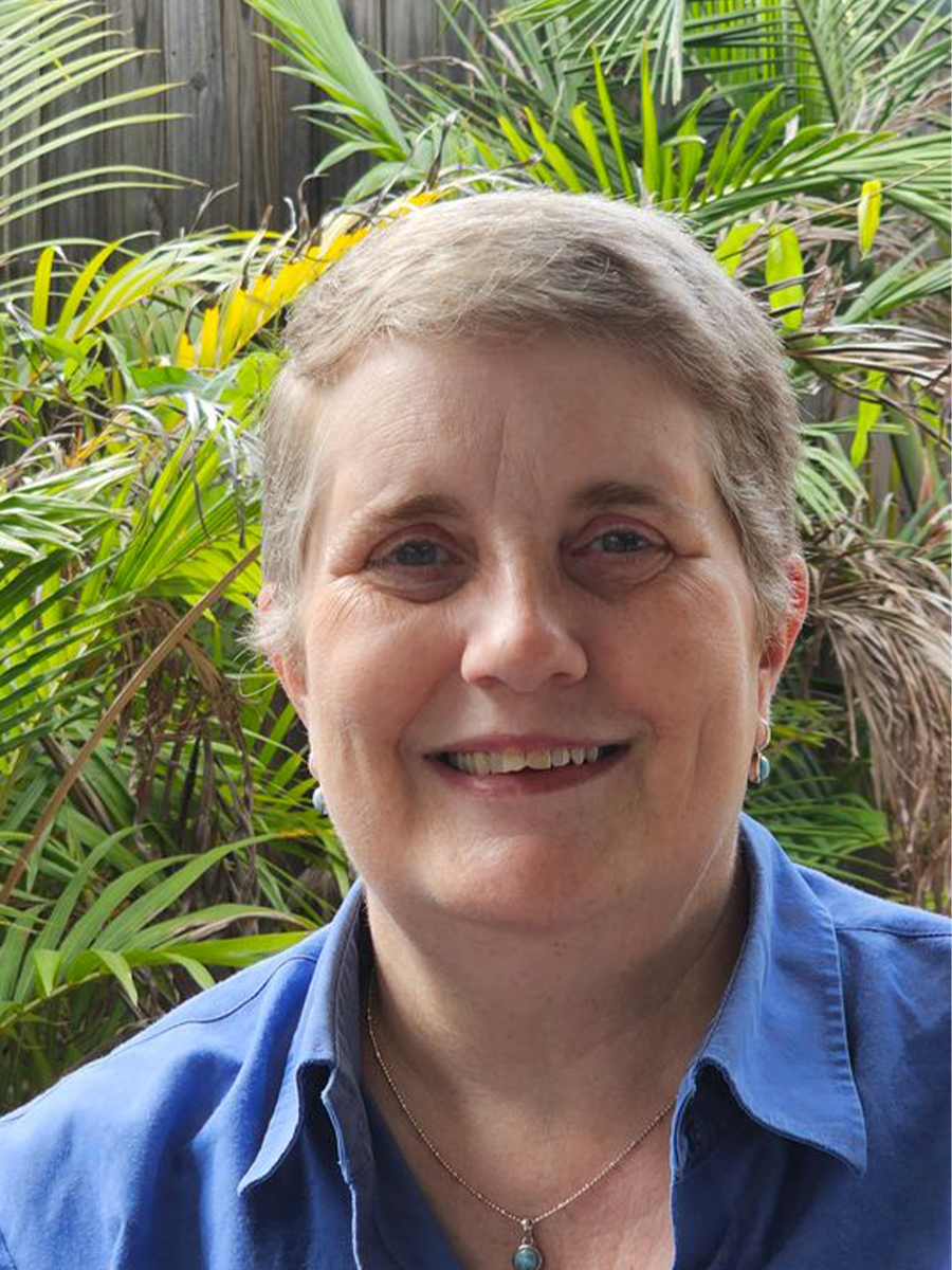 Karen Wilson headshot, wearing glasses and blue top, smiling at camera