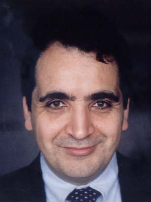 Headshot of Cuross Bakhtiar smiling faintly and wearing a dark suit jacket.