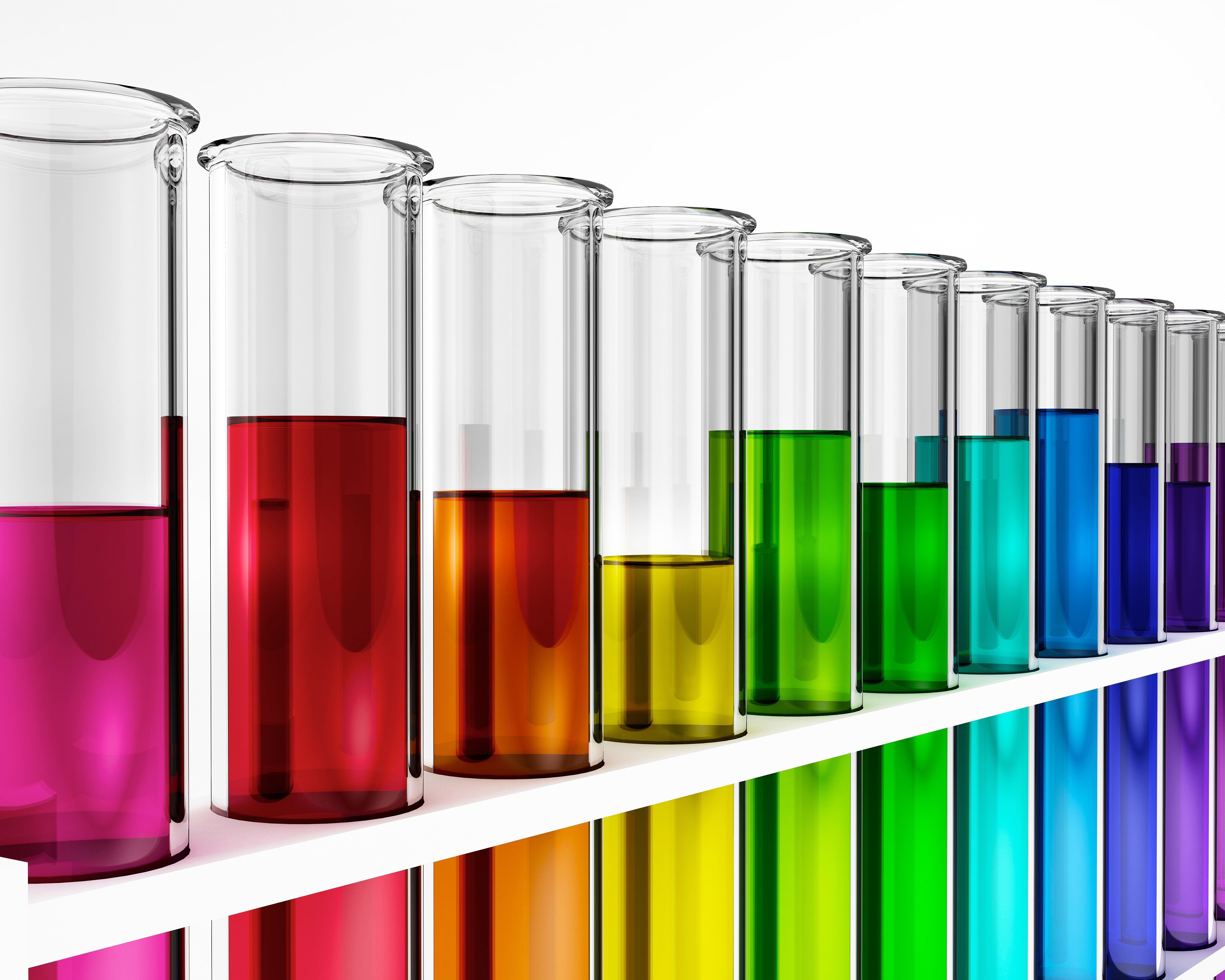 A series of test tubes filled from left to right with rainbow-coloured liquids