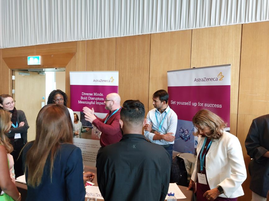 Several programme participants visit the stall of AstraZeneca