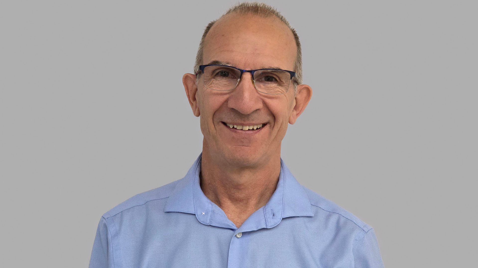 Vicente Talanquer smiling to camera in glasses and blue shirt