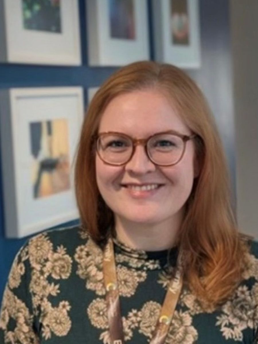 Emma Eley smiling to camera wearing glasses