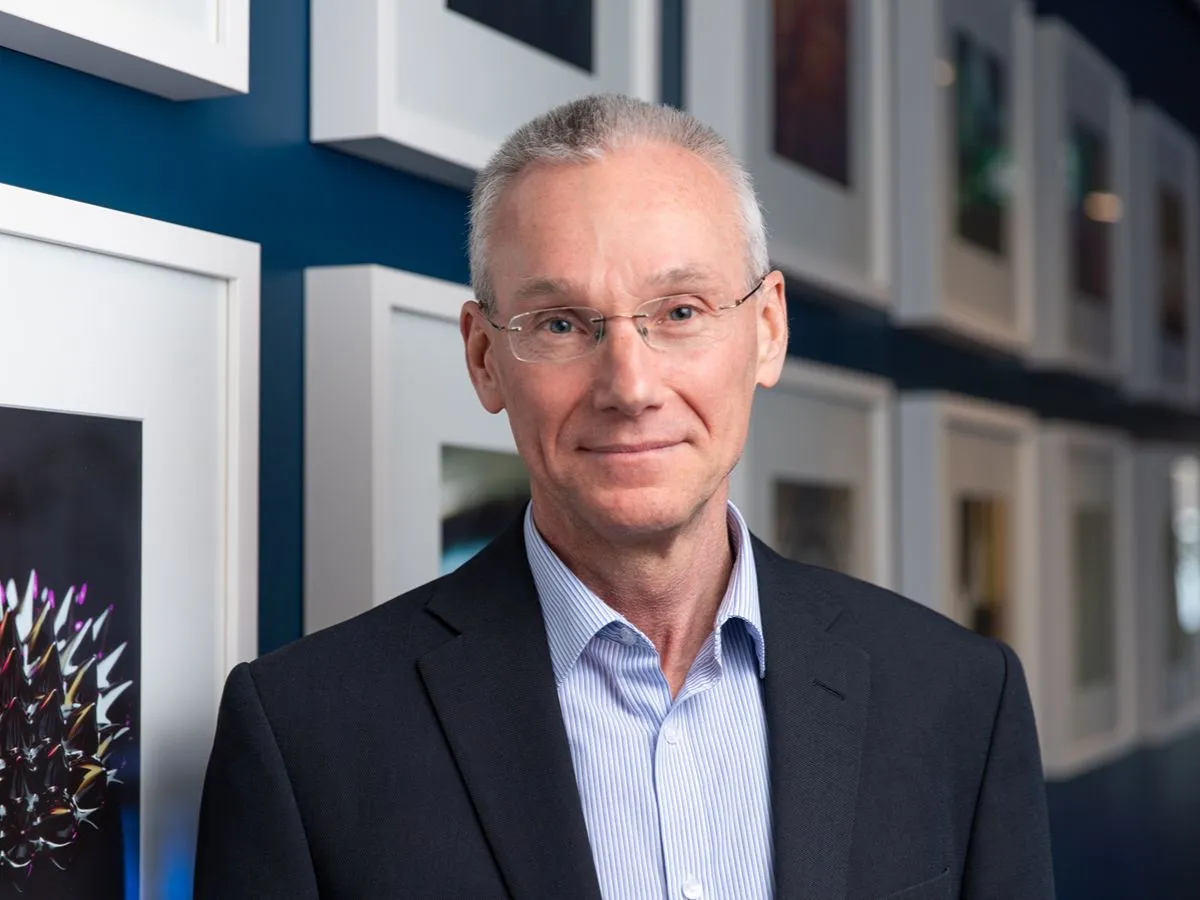 Rick Russell RSC landscape Rick Russell headshot smiling to camera wearing suit and glasses